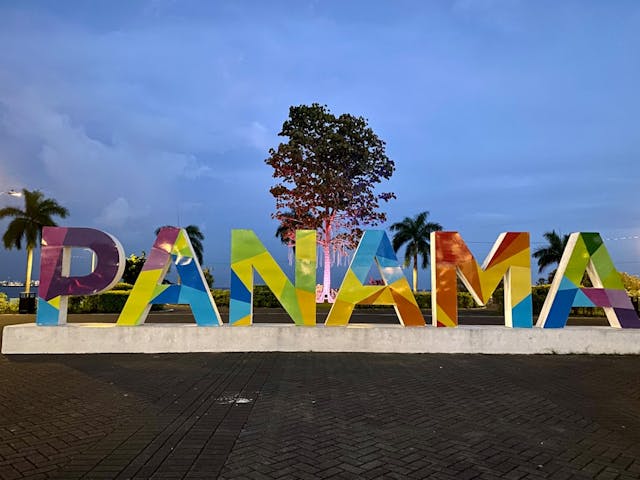 a large sign that says panama with a tree in the background