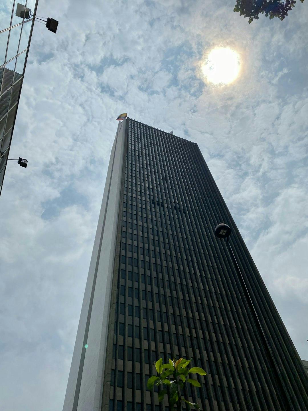 a very tall building with a bright sun in the background